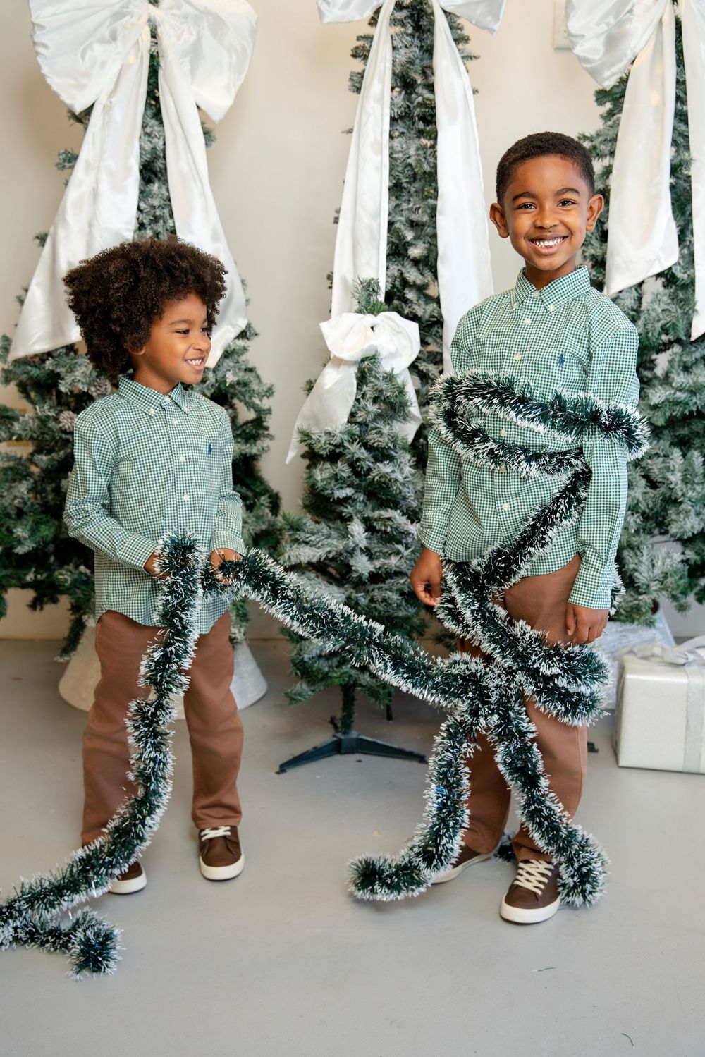 A series of photos showing someone playfully wrapping themselves in sparkly green Christmas tinsel garland.
