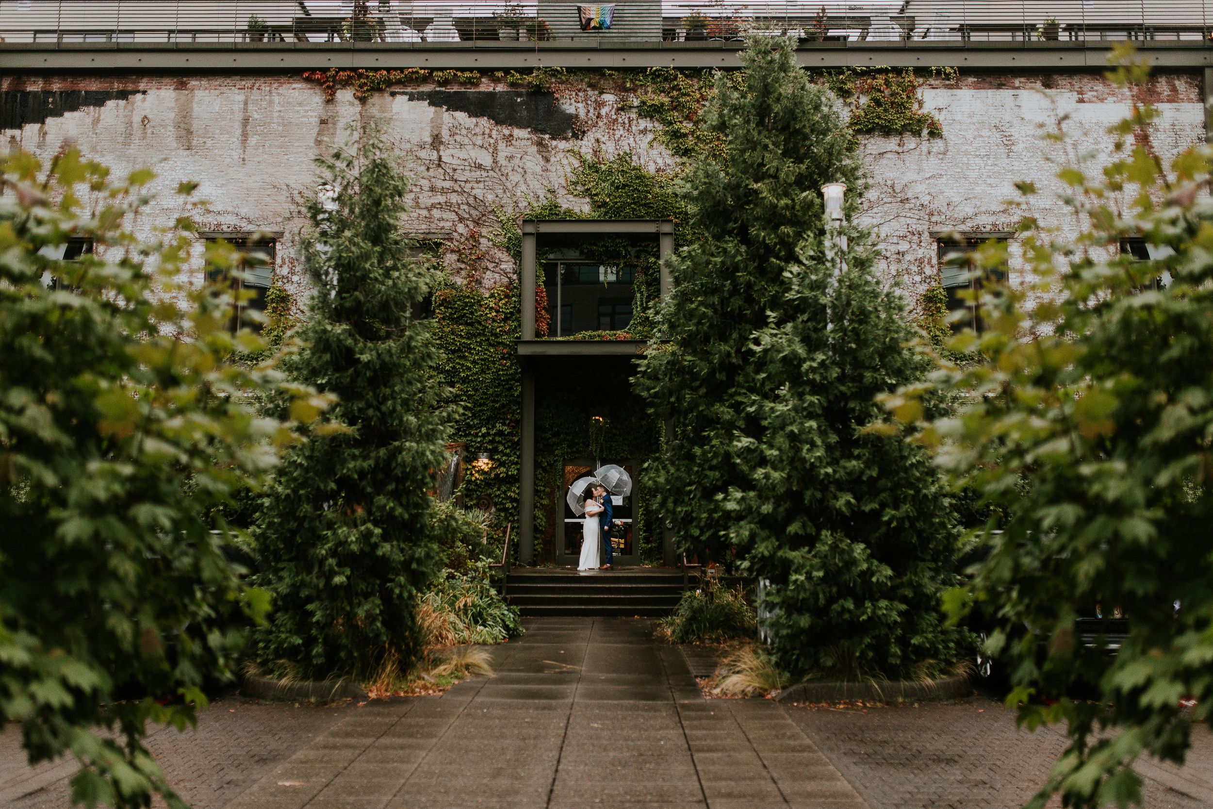 Garden pathway leads to vintage greenhouse surrounded by lush greenery at Ecotrust Events in Portland. Oregon wedding photographer.