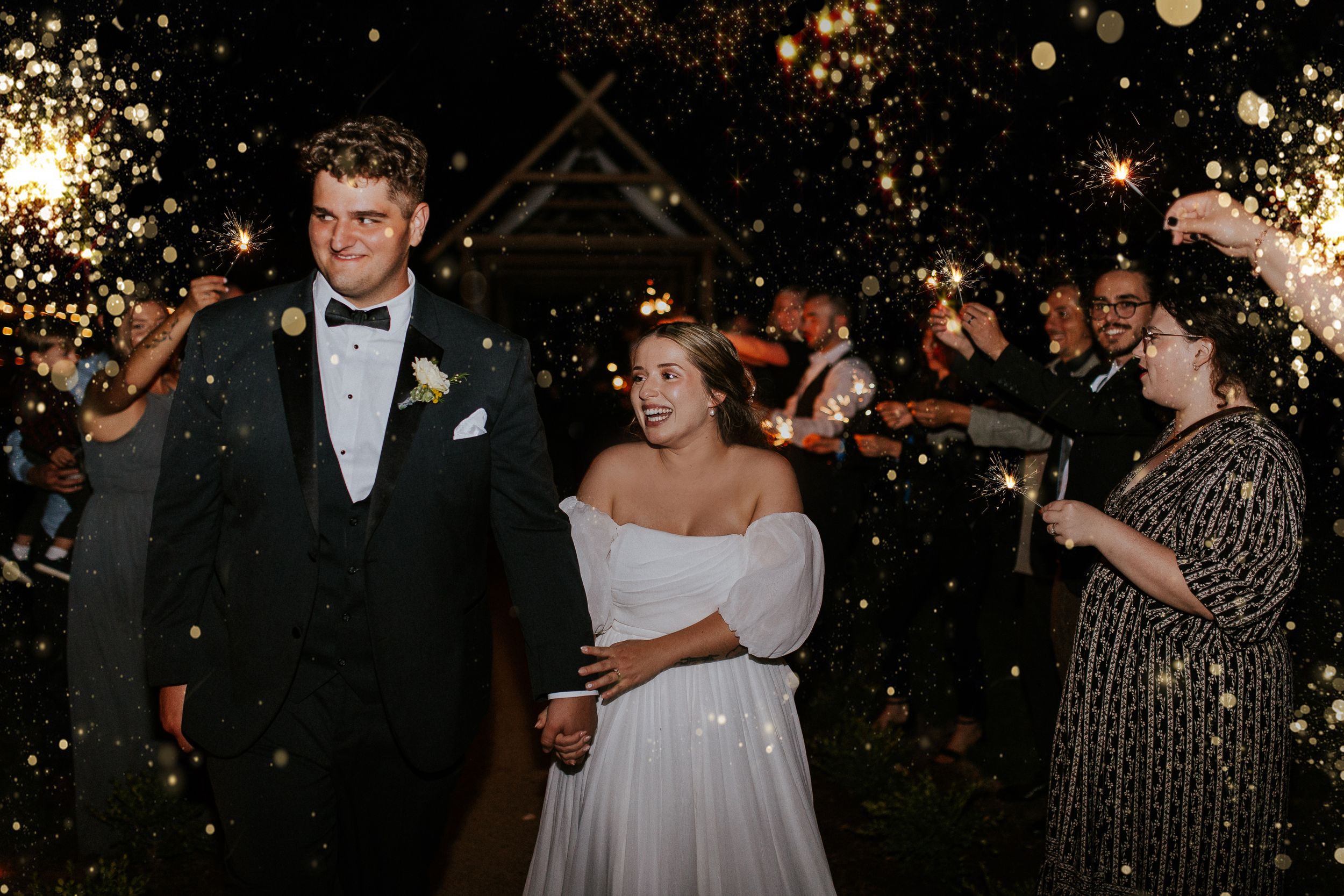 Wedding reception at night with string lights creating magical bokeh atmosphere. Wedding reception exit, wedding photography.