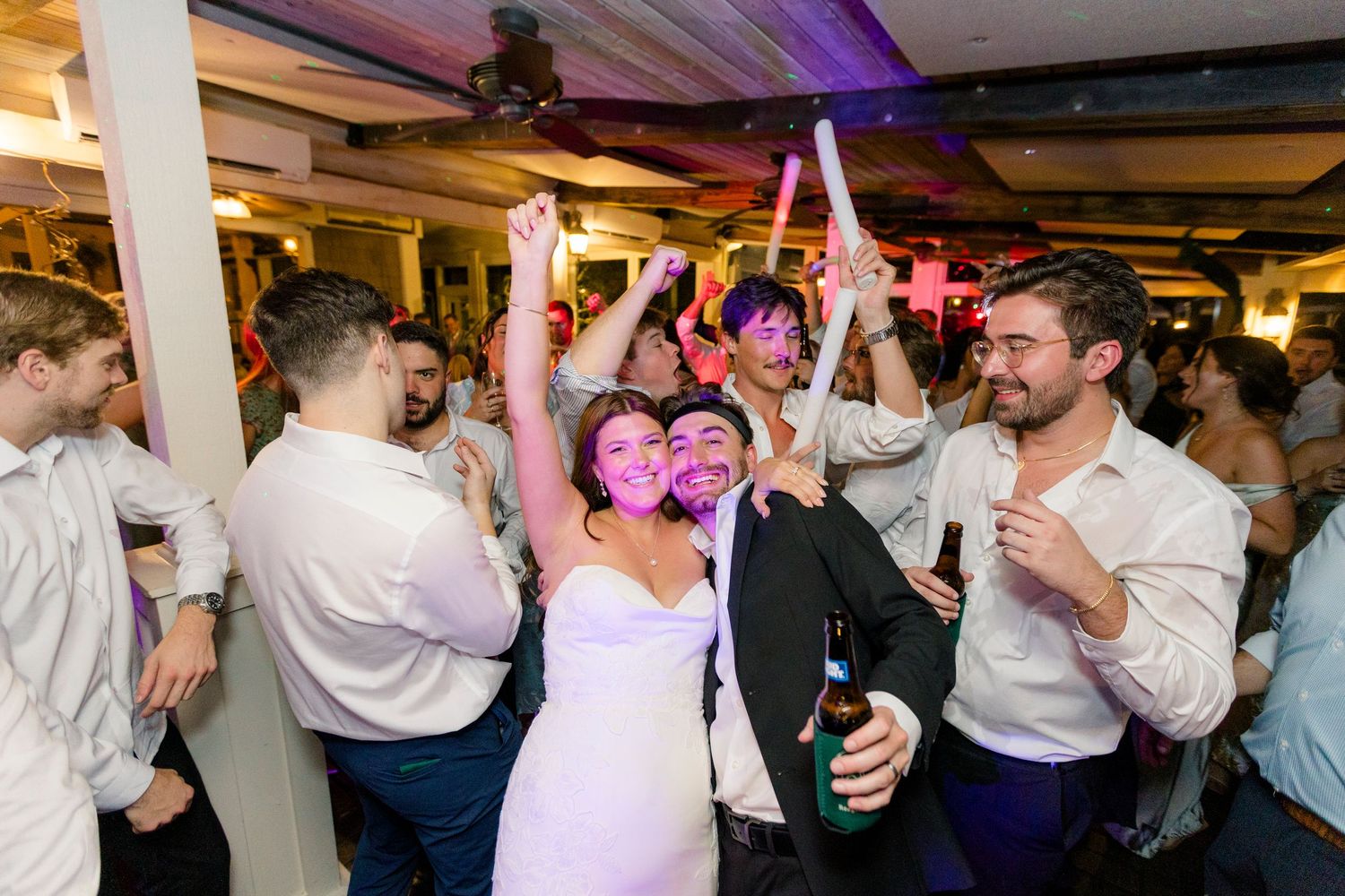 Bride and groom dancing joyfully with guests at Wolf Mountain Vineyards wedding reception party.