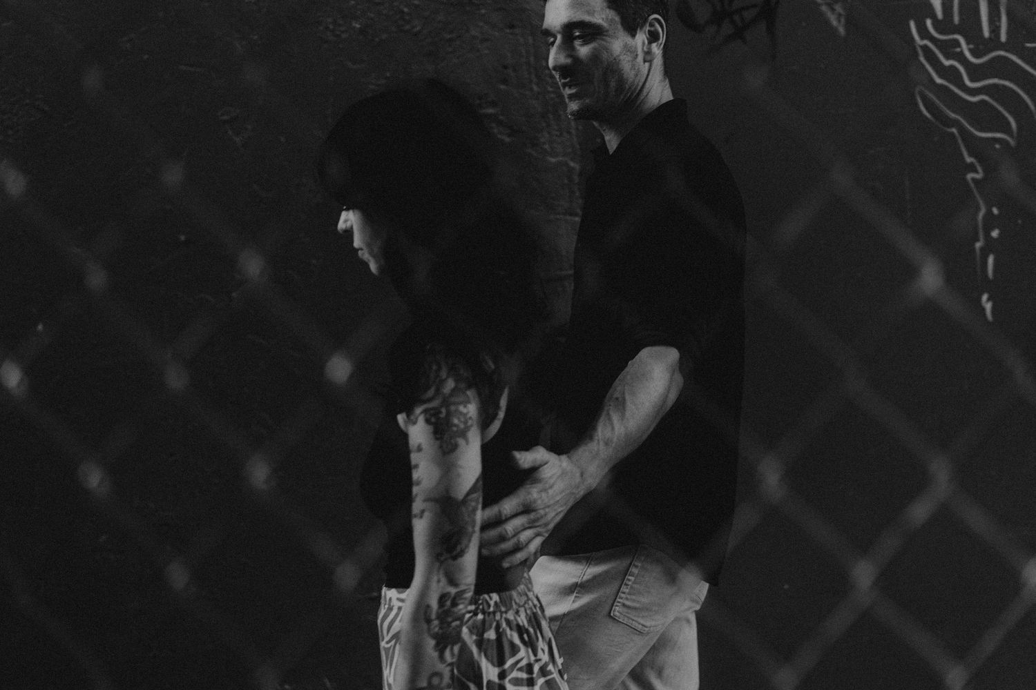 A black and white photo shows two dancers performing an intimate partner dance with dramatic posture and form.