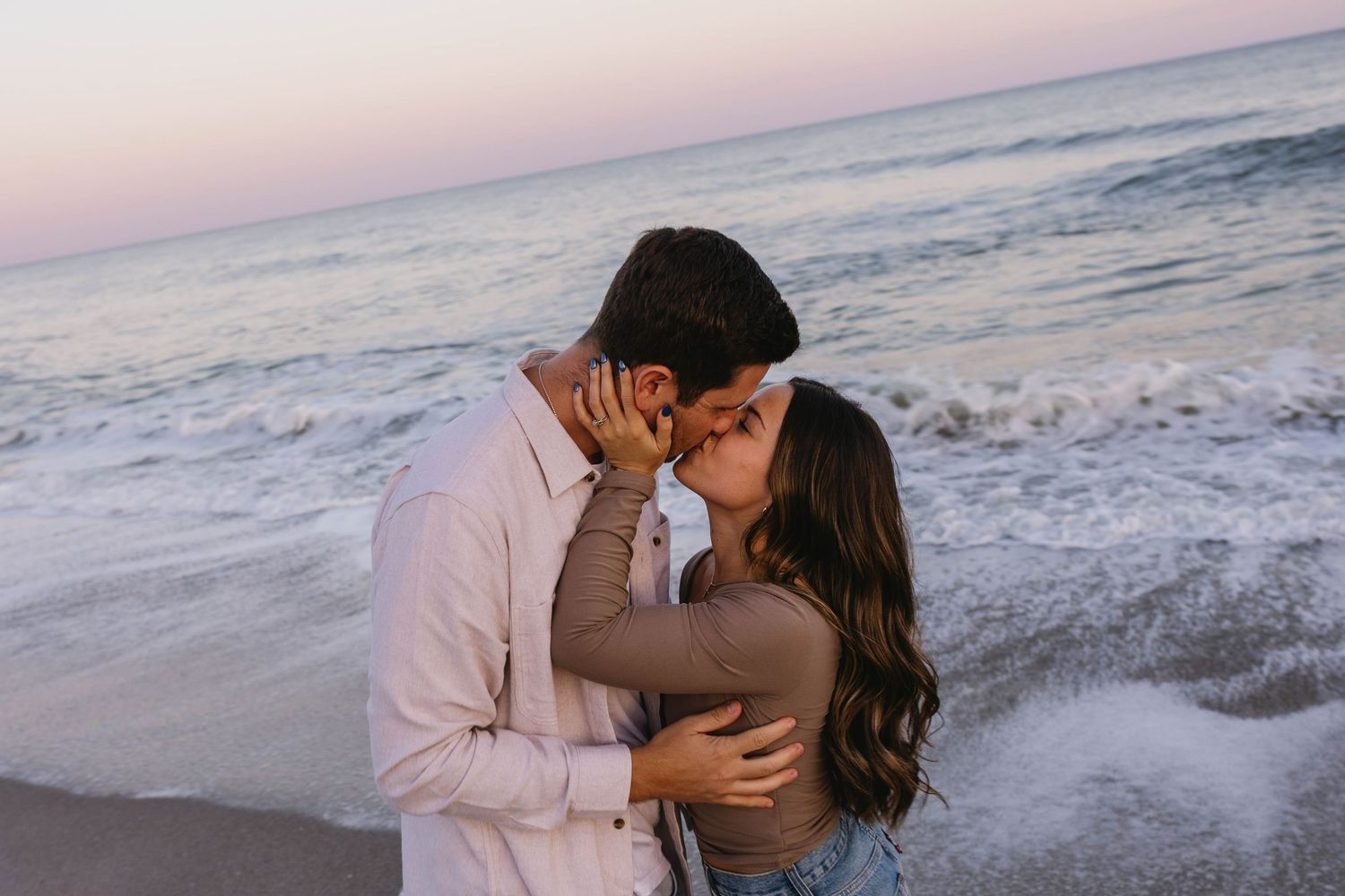 couple running by the waves at the beach at sunset