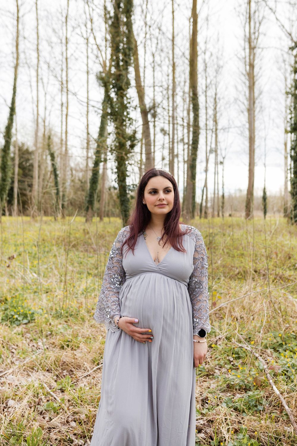 Femme enceinte portant une robe vaporeuse posant en forêt, shooting photo grossesse féerique et naturel près de Niort.