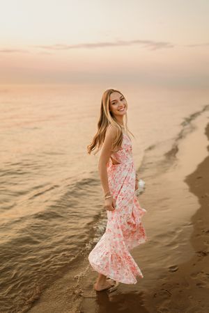 Michigan beach senior portraits. South Haven. Senior laying on beach. Beautiful Sunset.