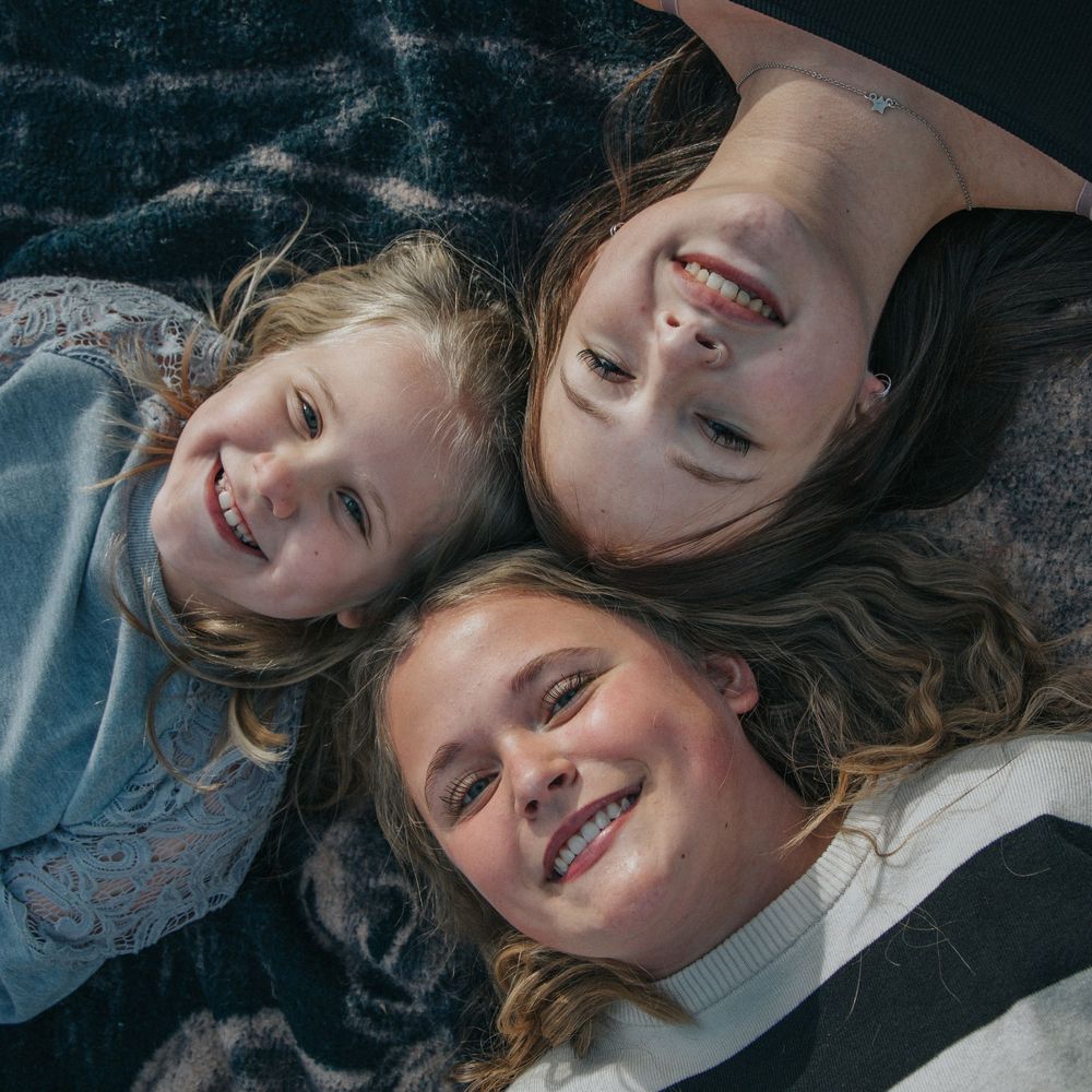 A sequence of images showing a person with long hair lying on a dark surface while expressing different emotions and poses.