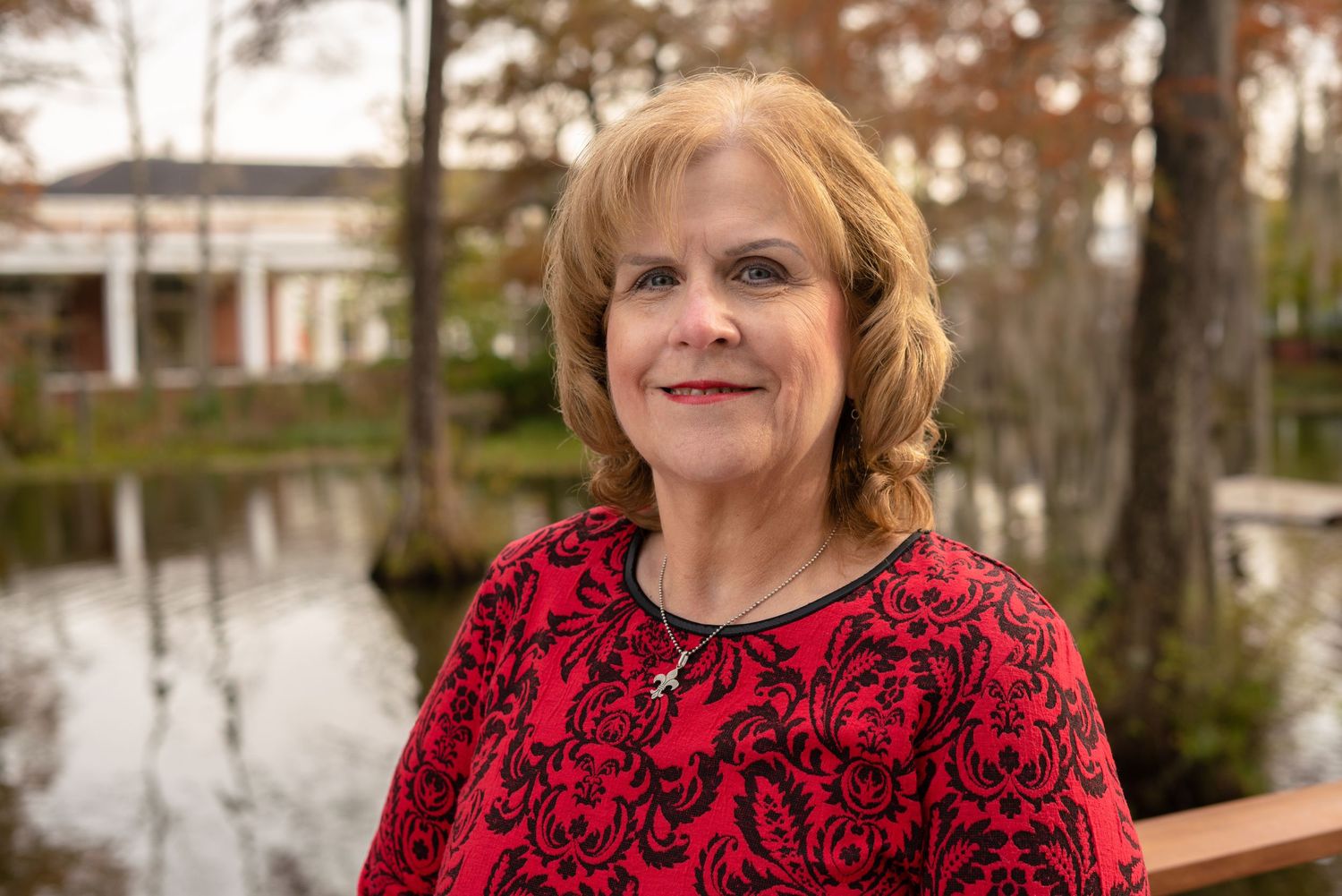 Person wearing a black dress and white lace cardigan posing outdoors.