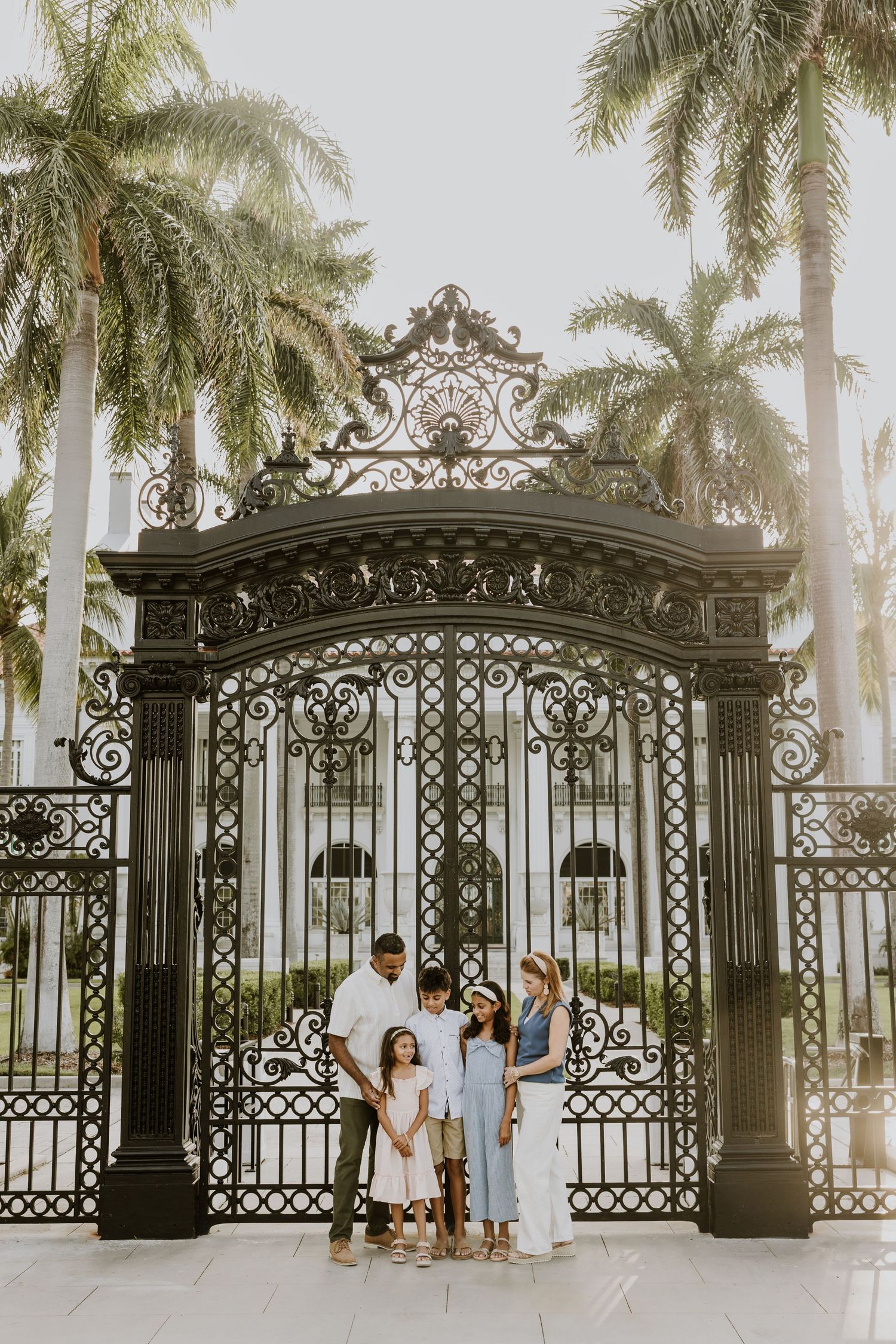 Golden hour summer family photos captured by Lindsay McDow Photography in front of Flagler Museum and in park by water on Palm Beach Island