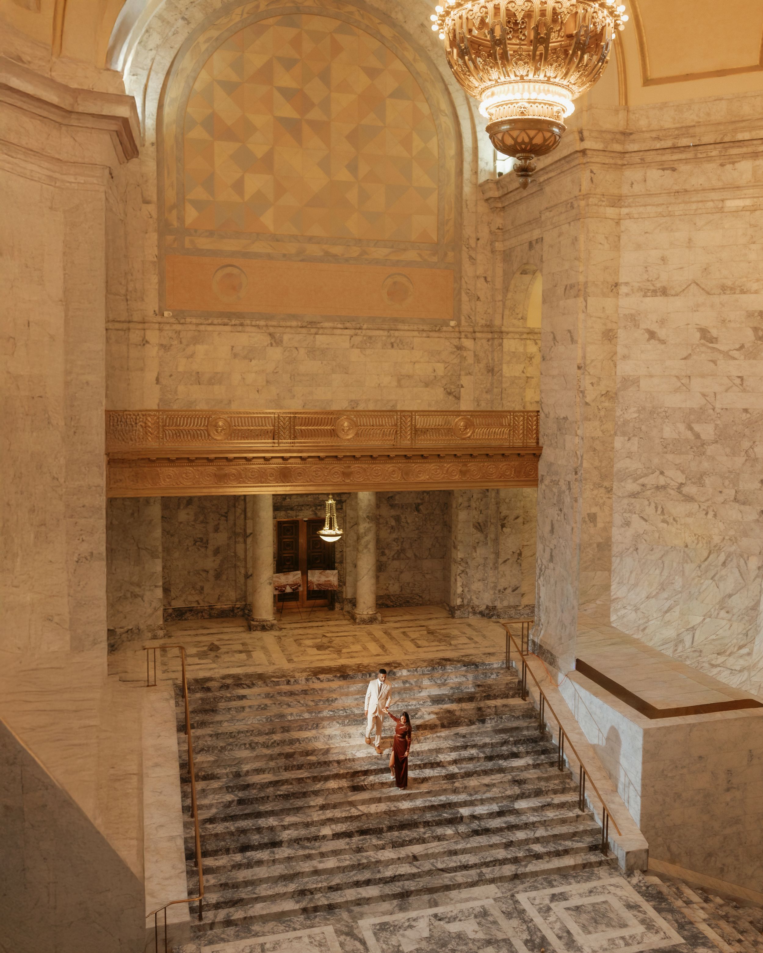 Historic stone cellar with vaulted ceilings, marble columns and ornate crystal chandeliers illuminating the underground space.