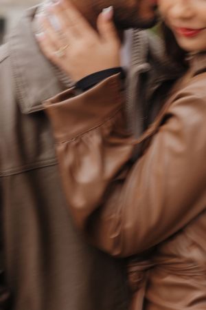 Close-up details of brown leather jacket folds and textures in warm lighting.