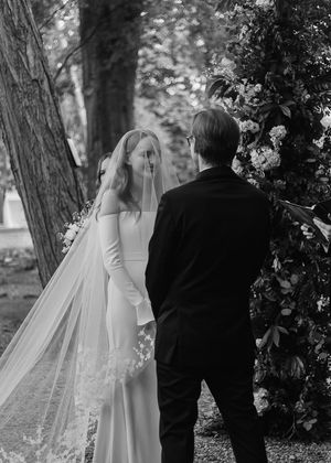 Black and white wedding portraits showing couple walking together through a tree-lined path.
