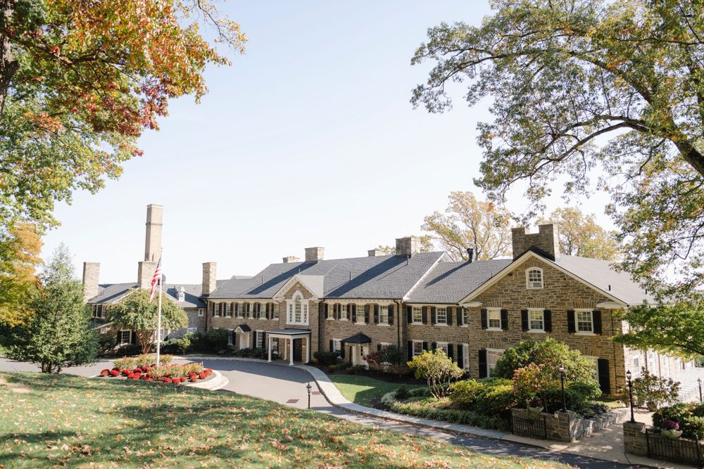 The elegant Manufacturer's Golf club nestled on a hillside with autumn trees and landscaping during fall season.