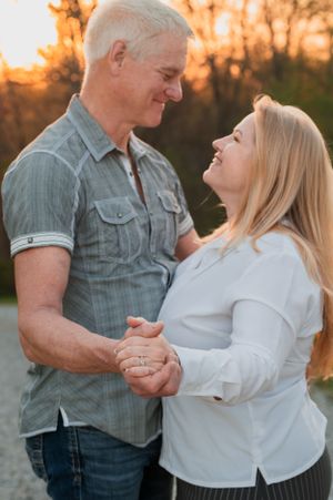 Couple dancing and smiling together during golden hour outdoors.