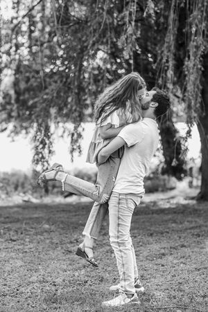 Romantic couple sharing a playful lift moment in black and white photography.