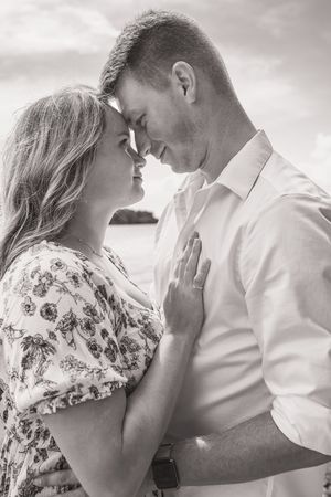 An intimate black and white portrait of a couple sharing a close moment together.