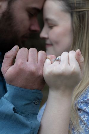 Close up of couple's pinky promise while wearing engagement ring.