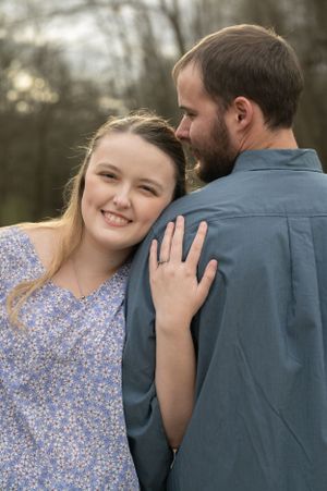 Couple laughs and embraces during romantic outdoor engagement session.