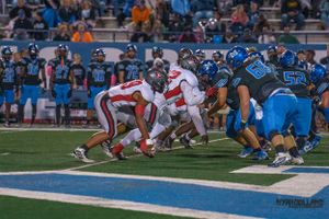 Football teams face off at line of scrimmage during intense game play.