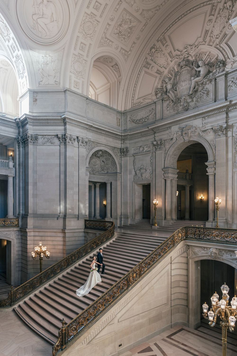 Bride and groom share a romantic moment on the grand staircase of San Francisco City Hall.