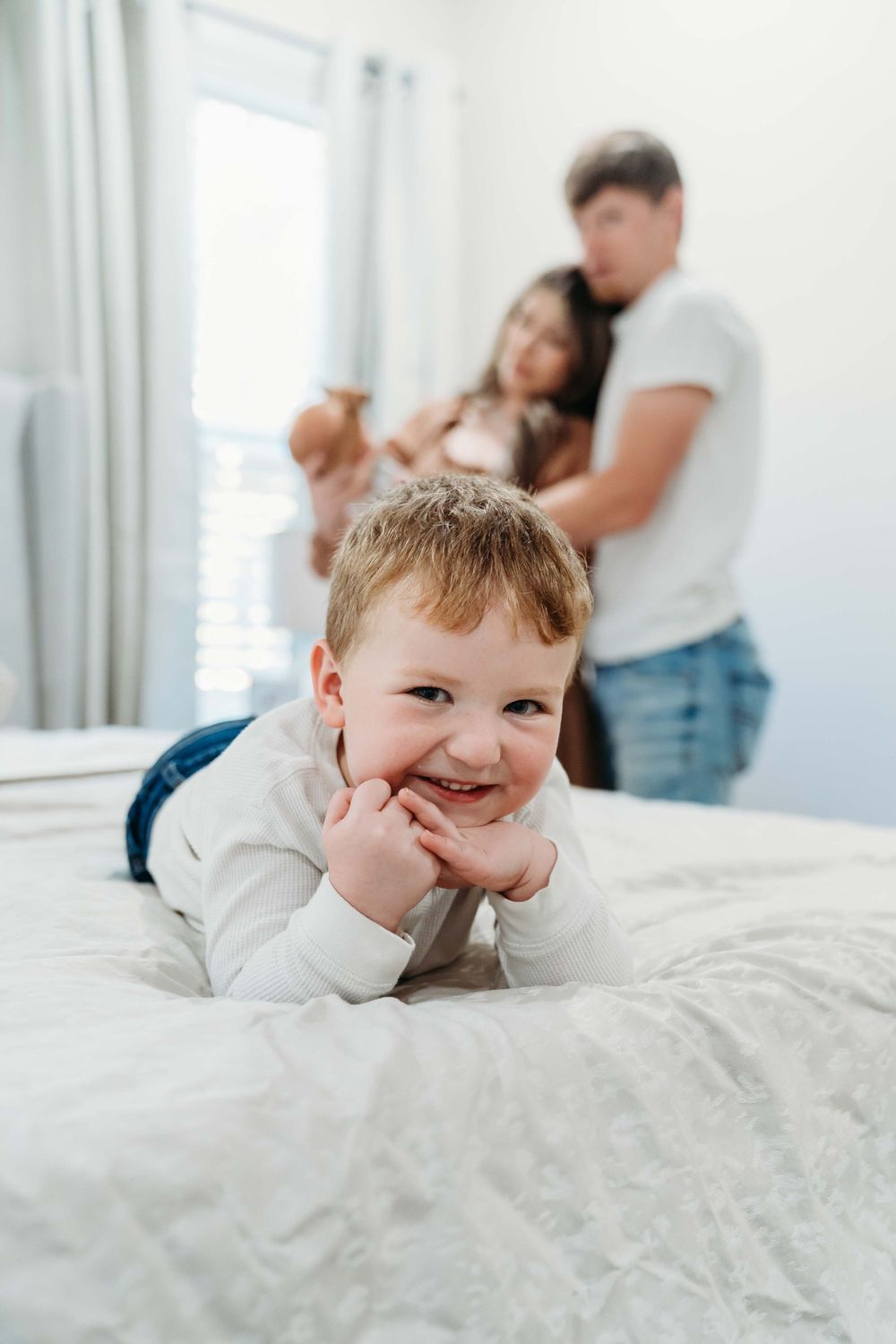 A bright white bedroom setting with family moments captured in natural light.