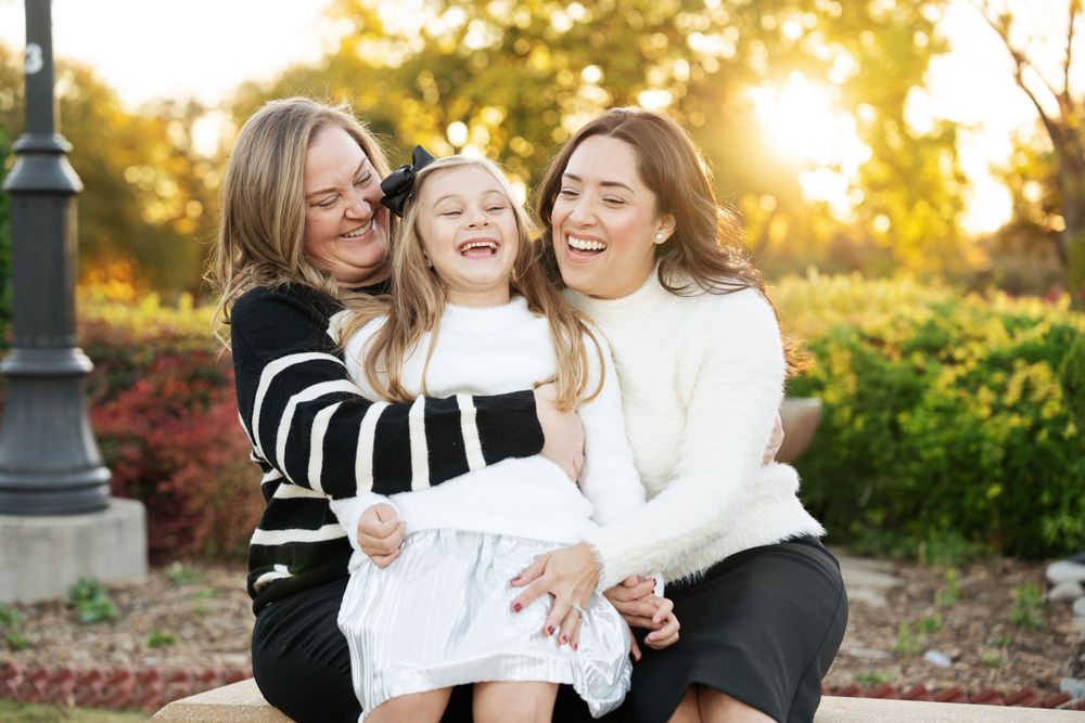 Family portrait session at sunset with warm golden lighting in park setting.