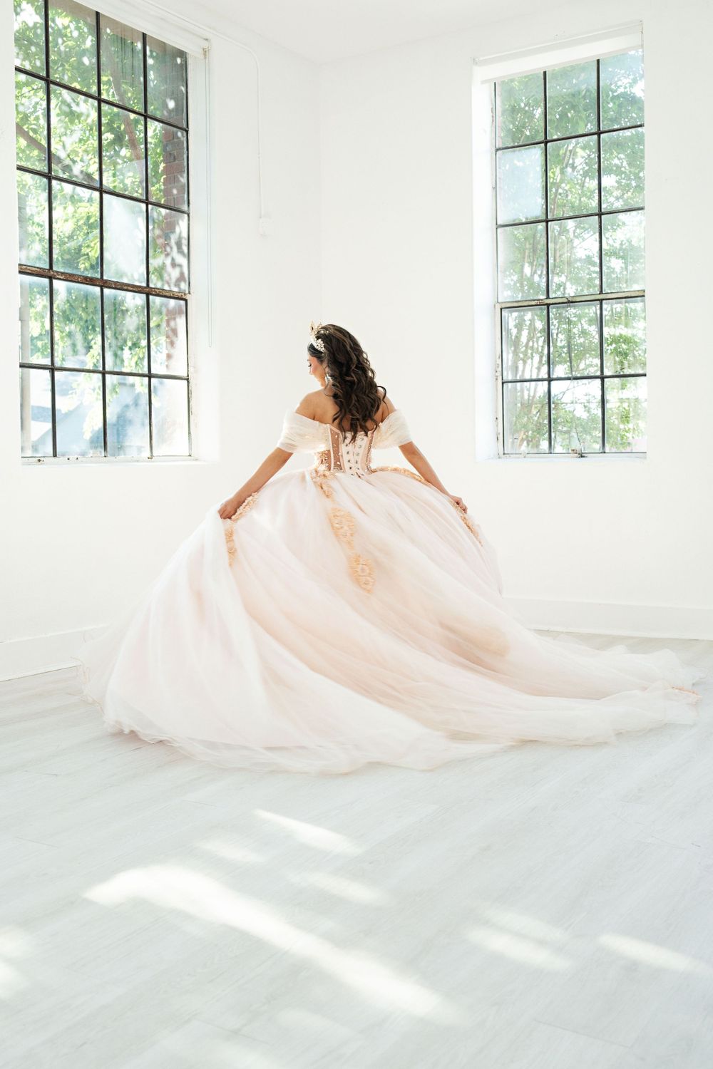 quinceañera dancing or spinning in large white room