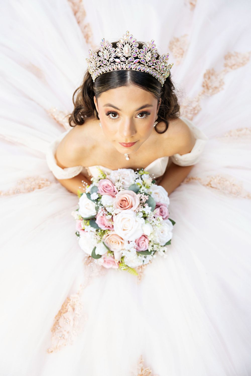 quinceañera sitting looking up with bouquet