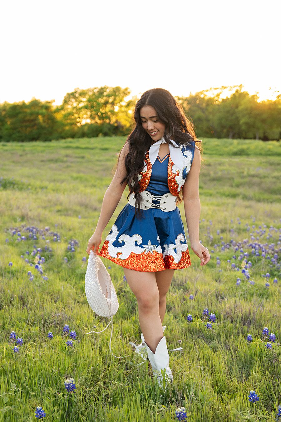 senior in drill team outfit talking in field in Plano