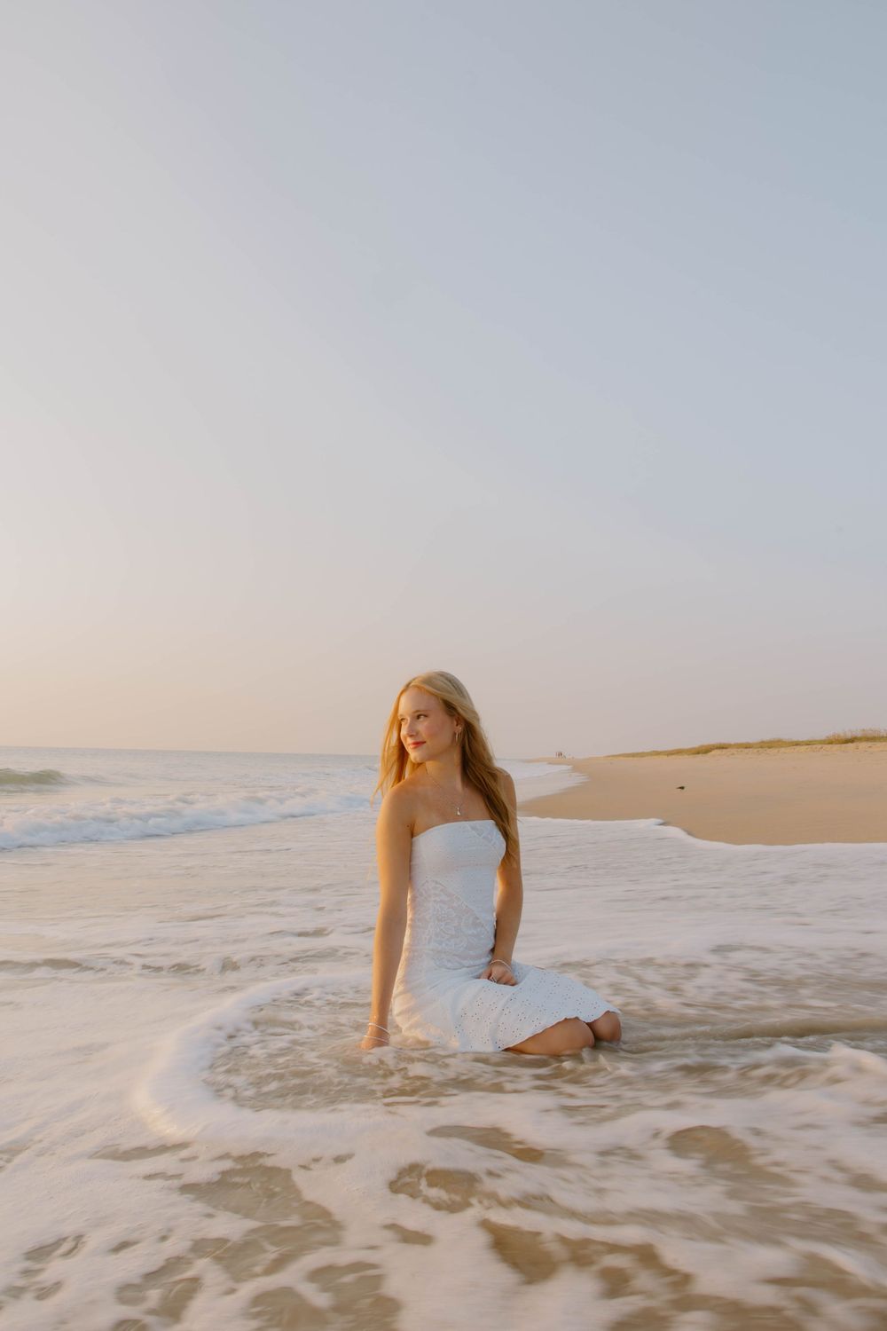Sunset beach bridal portrait with waves and soft lighting.