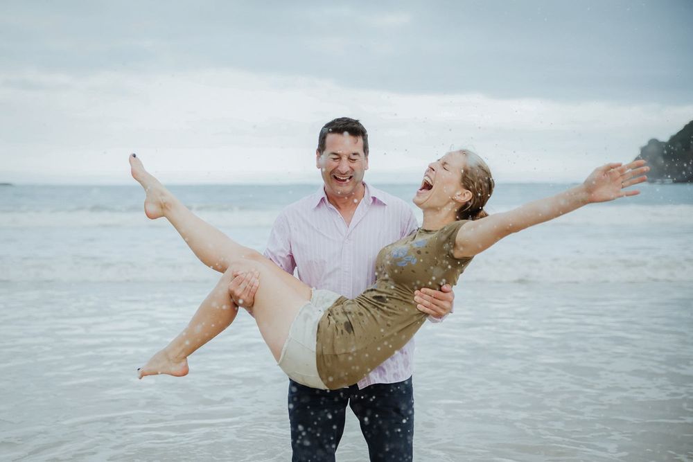 A playful beach scene with splashing water and laughter.