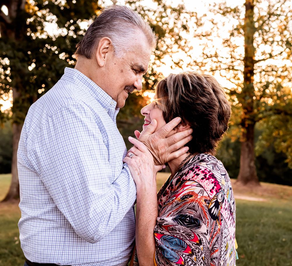 Intimate portrait of couple sharing tender moment outdoors at sunset.
