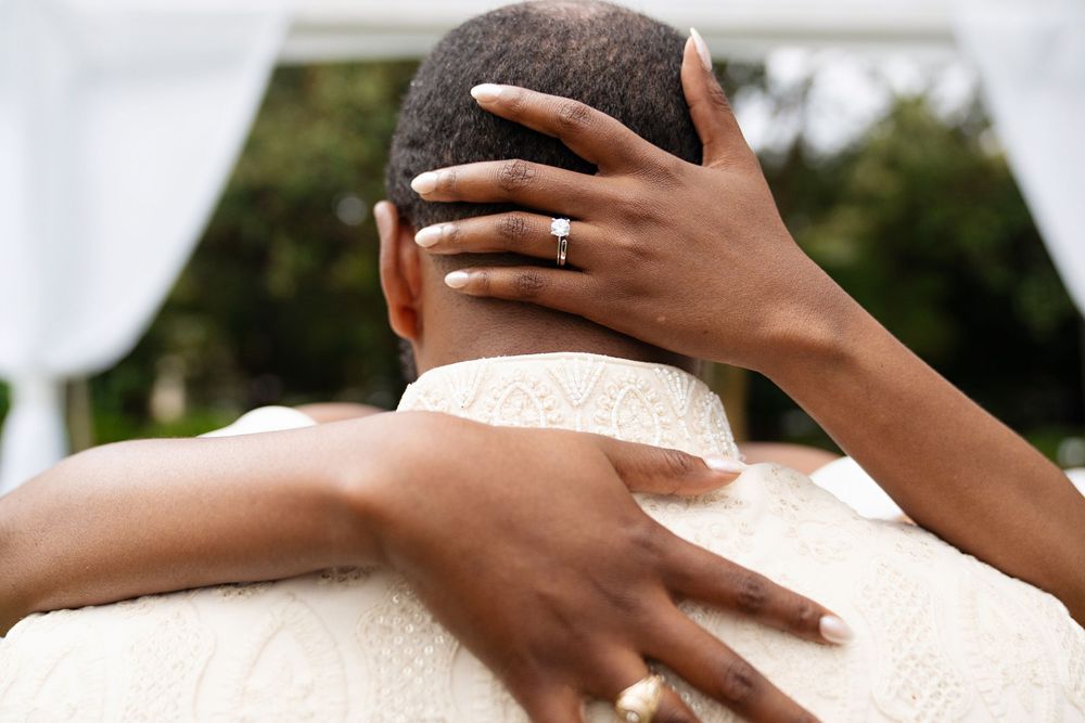 hands wrapped around grooms head showing diamond ring