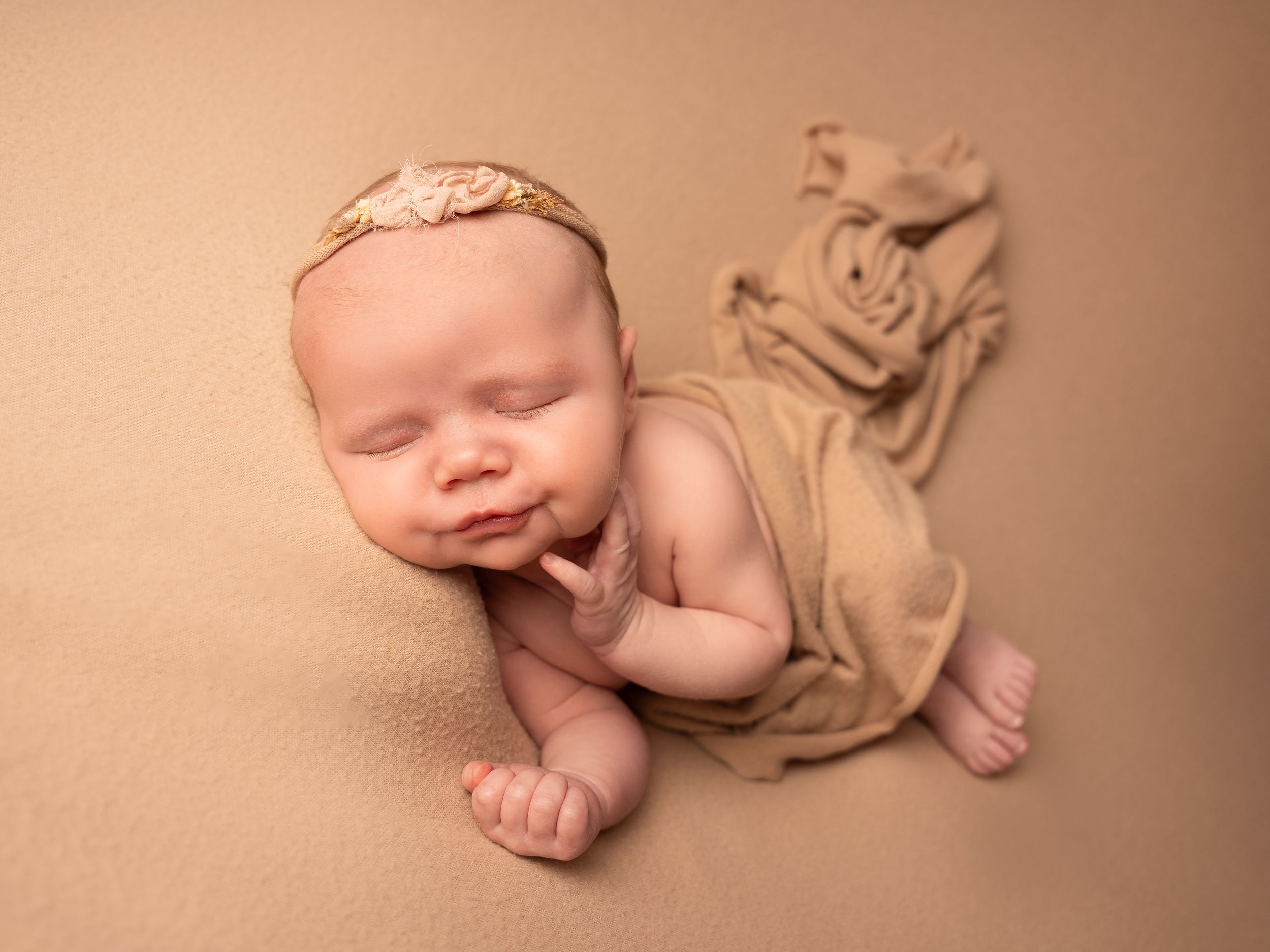 Newborn baby girl with floral headband sleeping at photoshoot by newborn photographer in Doncaster