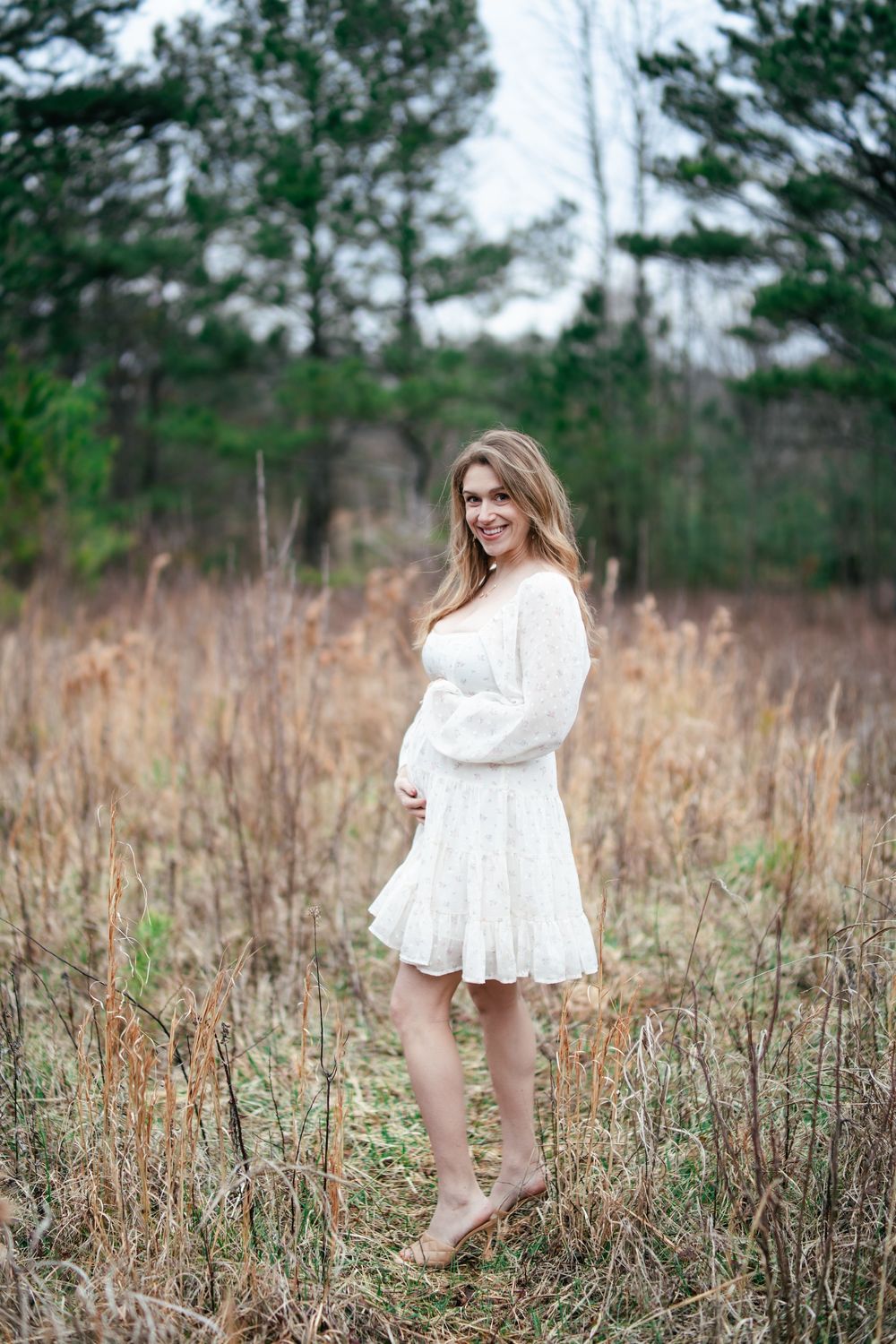 Pregnant women in a field holding her belly