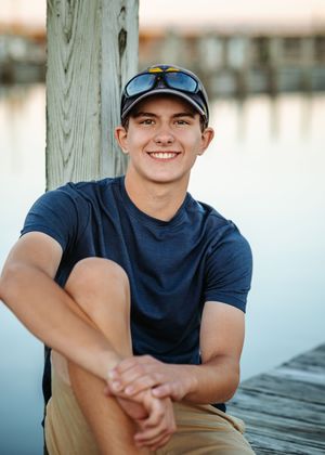 A set of casual outdoor portrait photos showing someone in a navy t-shirt and baseball cap at a waterfront location.