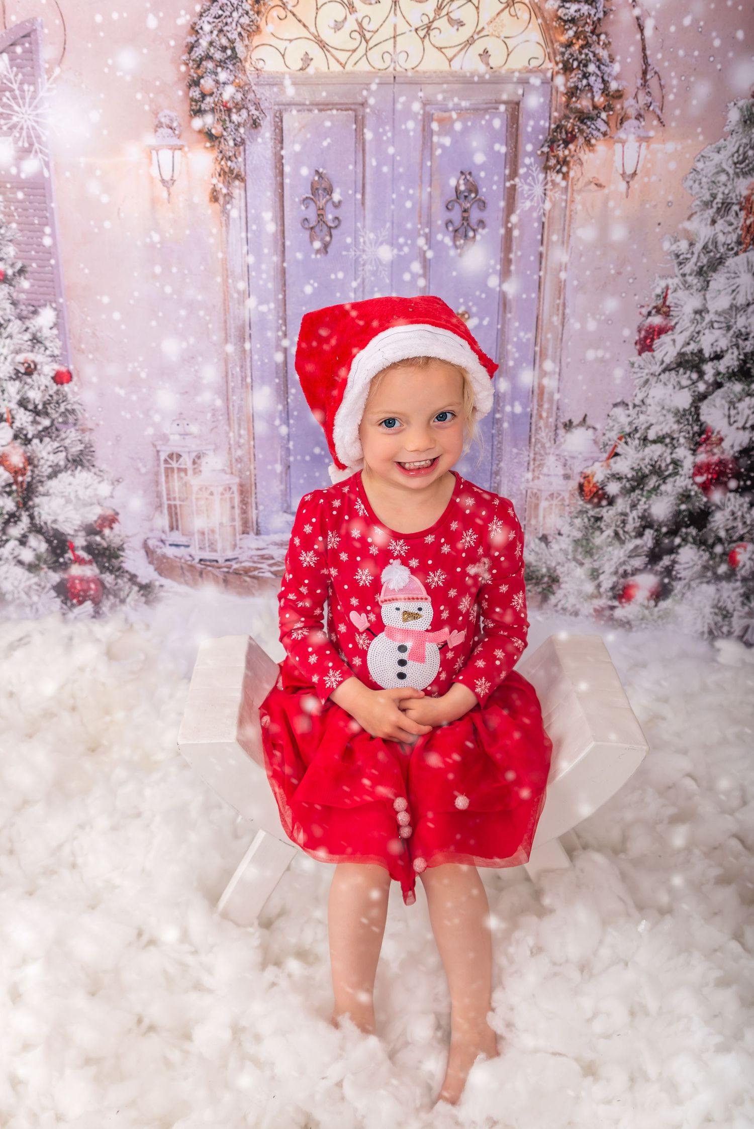 Little girl sat in Santa's sleigh at her Christmas Photoshoot
