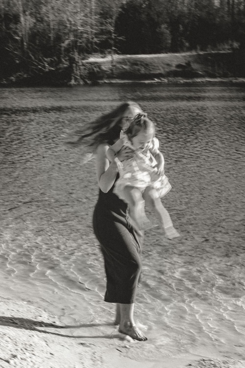 A vintage black and white photo shows a playful moment at the beach.