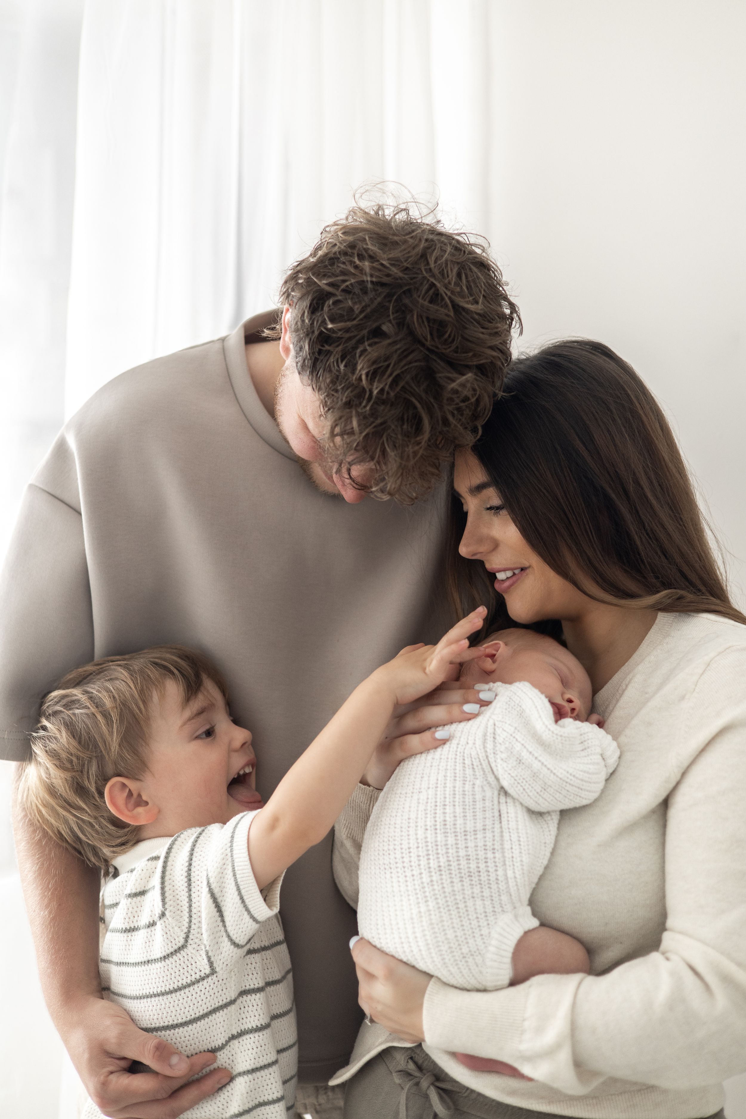 Parents cuddling their newborn baby during a natural newborn family photoshoot in Nottingham