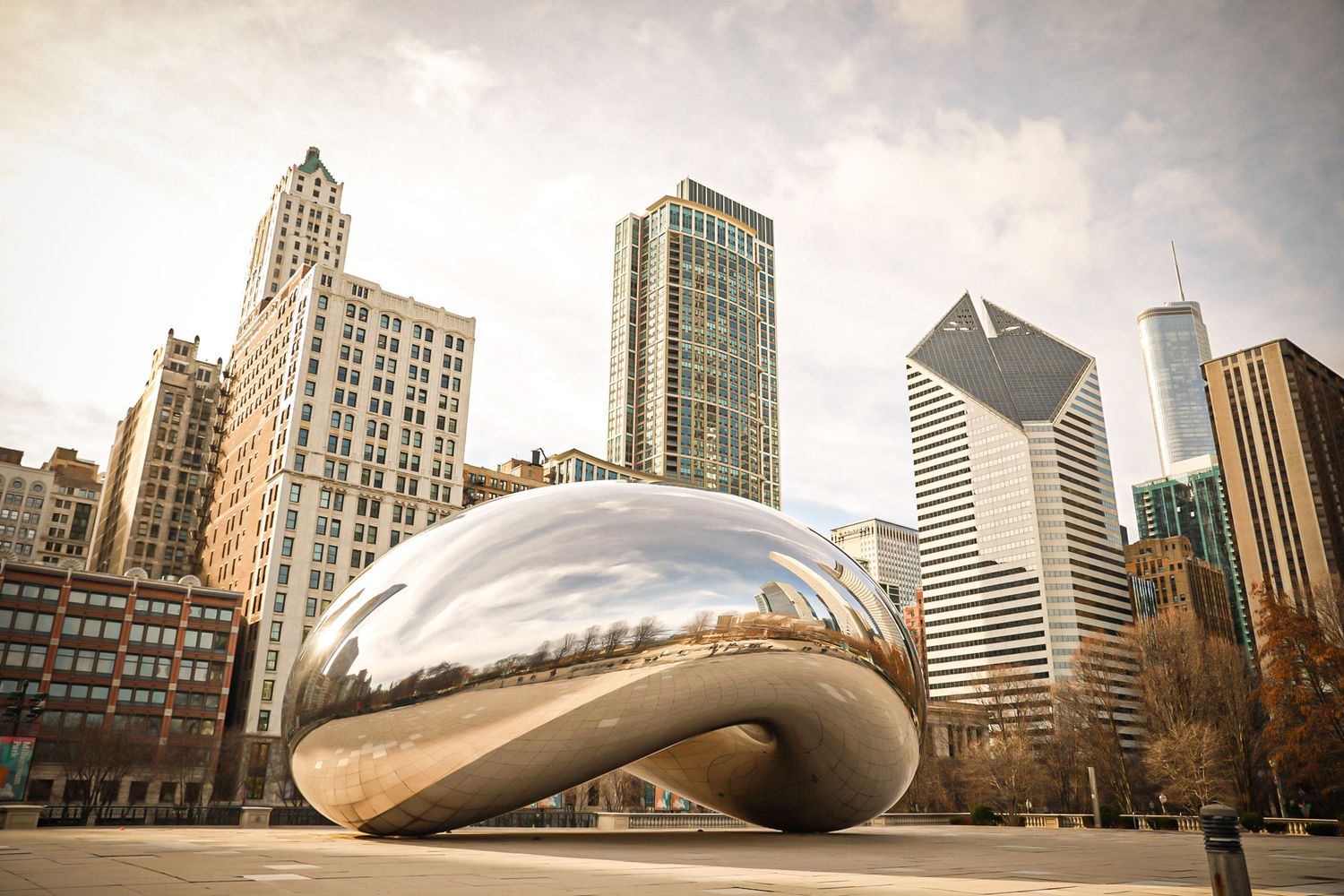The iconic Cloud Gate sculpture reflects Chicago skyline in Millennium Park on a cloudy day.