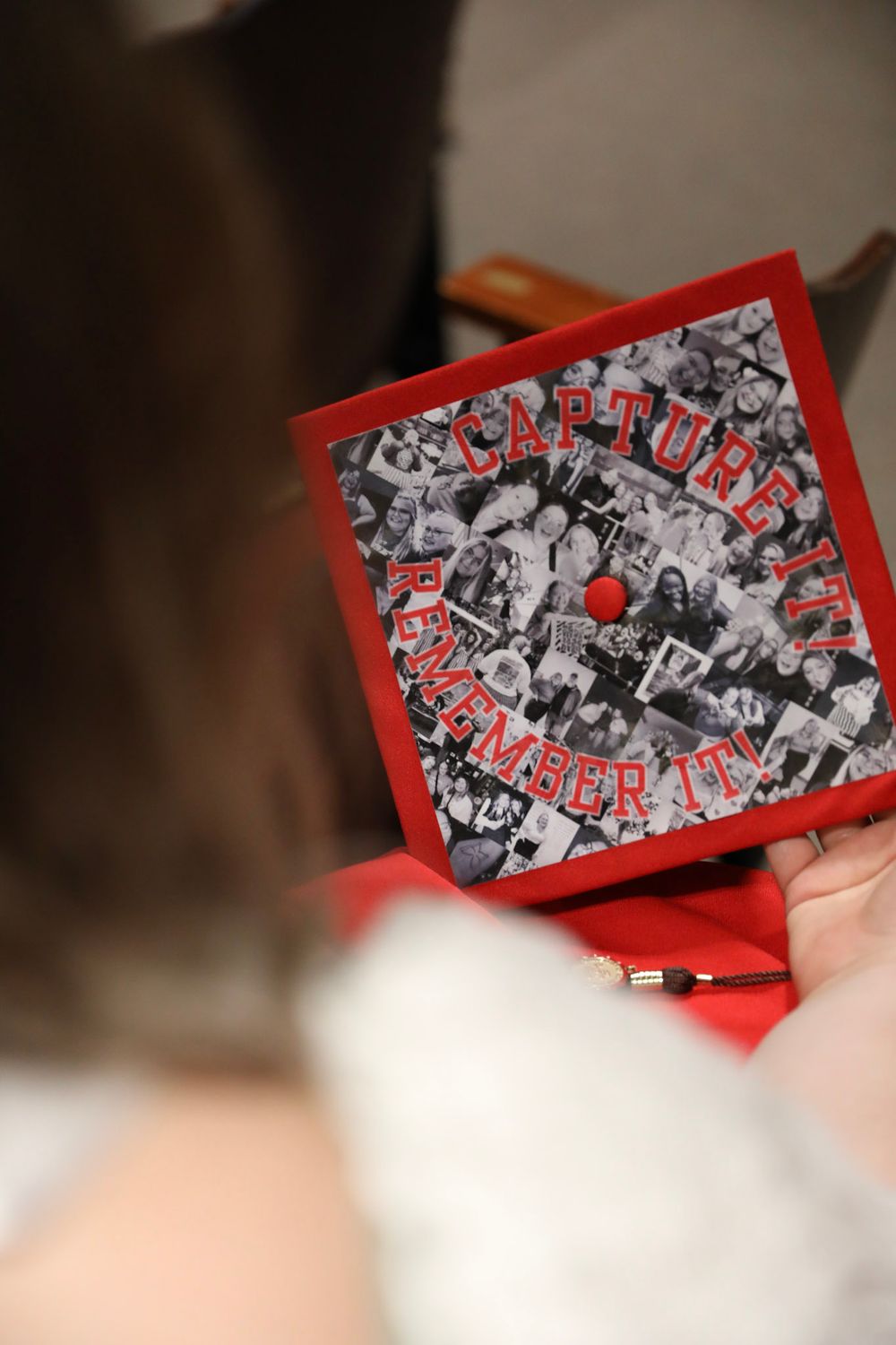 A decorated graduation cap with a photo collage and red text reading 'Capture It, Remember It'.