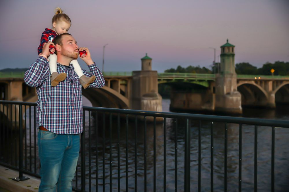 Scenic waterfront photoshoot with a bridge and sunset in the background.
