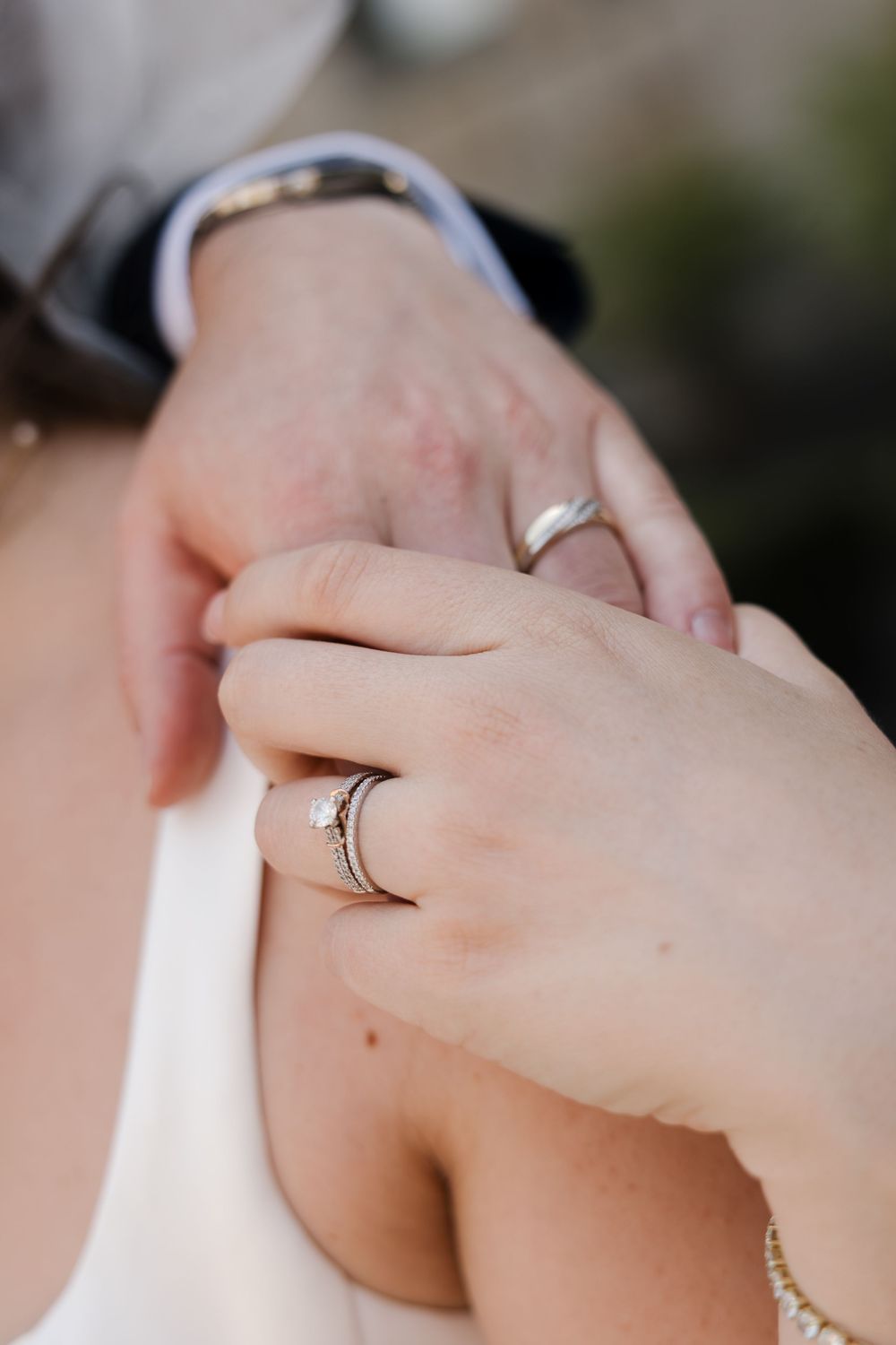 Close-up of bride and groom wedding rings on hands.