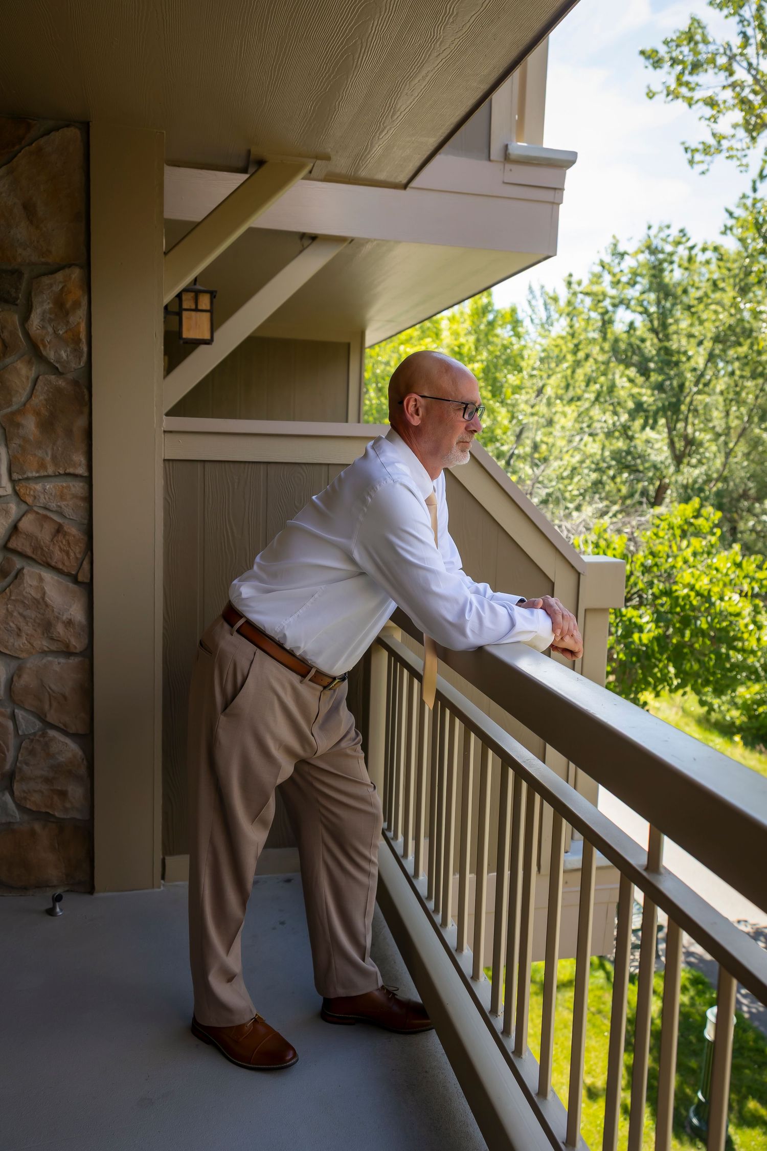 Groom on balcony of hotel before elopement Boise Elopement ©Milestones Studios LLC