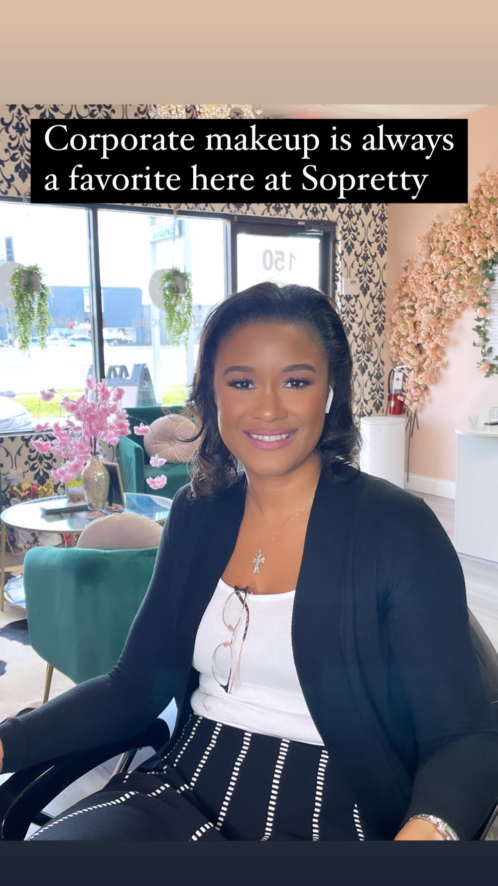 Woman in corporate makeup look wearing black blazer at kay Alvarez makeup salon, showcasing professional glam style.