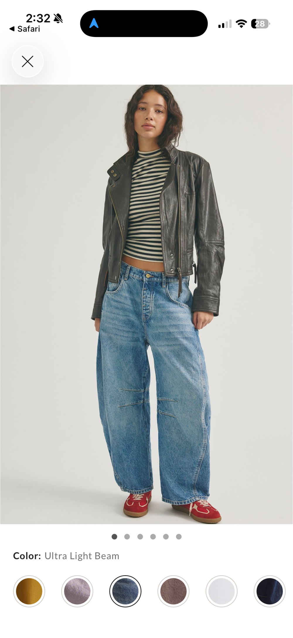 Woman wearing ultra light beam wide-leg jeans, striped crop top, leather jacket, and red sneakers.