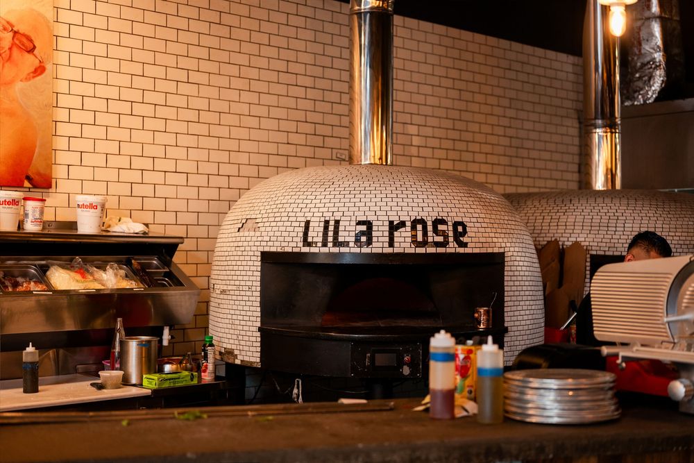 Lila Rose wood-fired pizza oven with mosaic tile design in a restaurant kitchen setting.