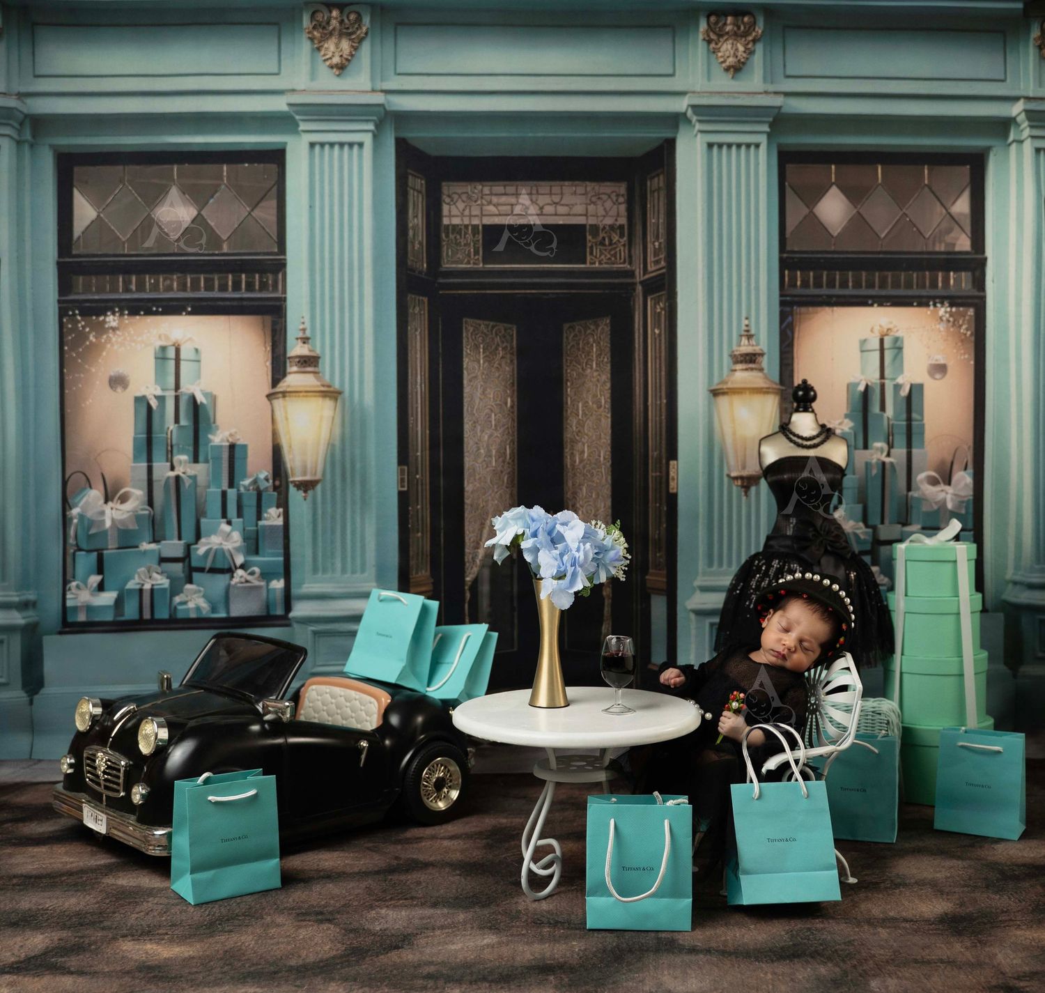 Baby posed in a Tiffany & Co. themed setup with teal gift bags, and elegant storefront backdrop. At the Affinity Studio in St Augustine