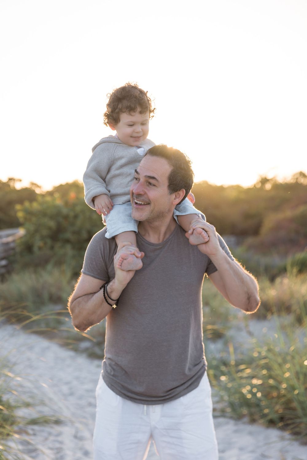 Father and child sharing playful moment outdoors at golden hour.