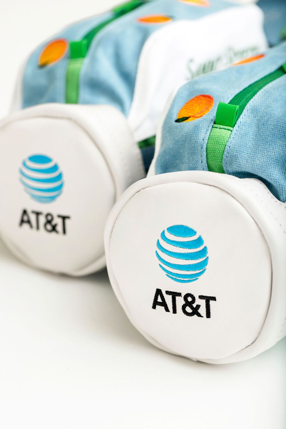 Two AT&T branded fabric golf bag accessories with blue globe logos on white circular ends.