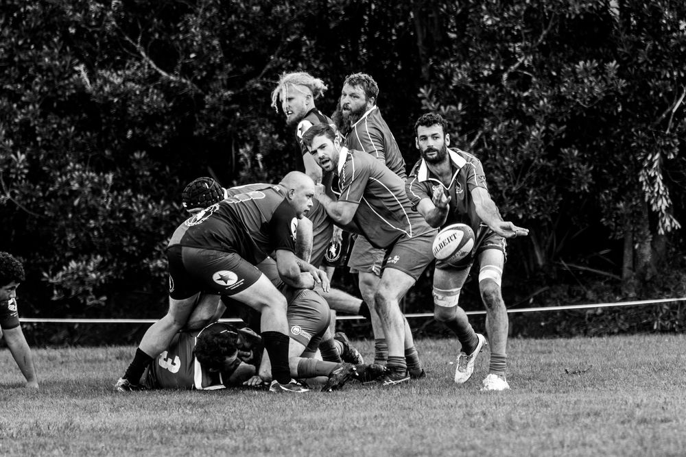 Rugby players compete in a scrum during a match in black and white.