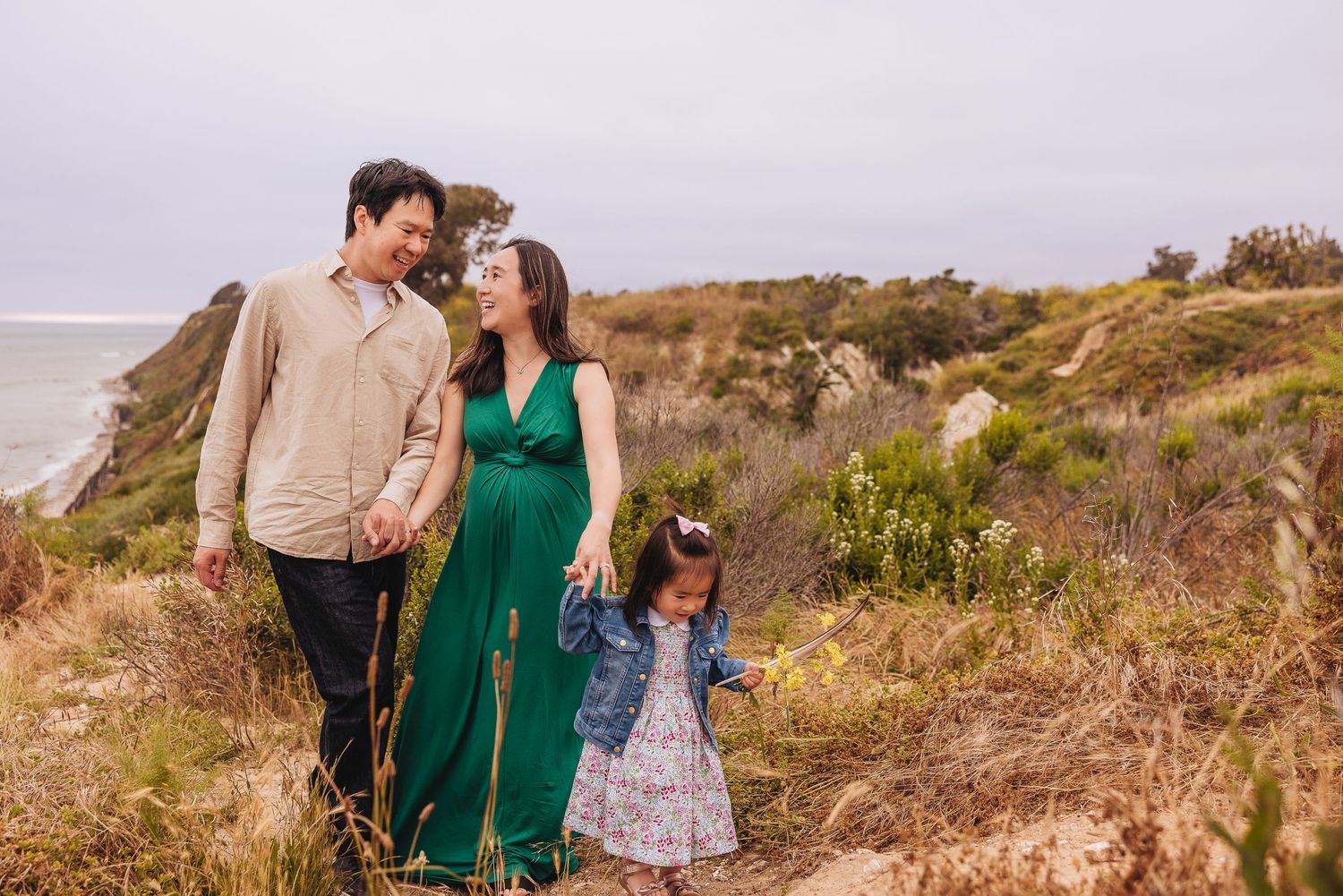 Santa Barbara family walking on Ellwood Bluffs with mom pregnant during maternity photography session